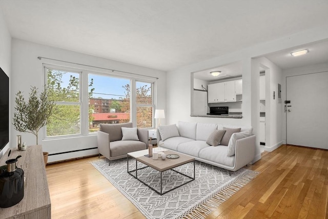 150 Main St Unit 12, Stoneham, MA 02180 - living area featuring a baseboard radiator and light wood finished floors