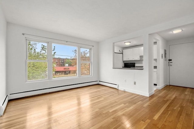 150 Main St Unit 12, Stoneham, MA 02180 - unfurnished living room featuring healthy amount of natural light, light wood-type flooring, and baseboards