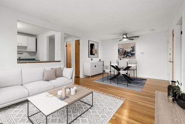 150 Main St Unit 12, Stoneham, MA 02180 - living room with light wood finished floors, a ceiling fan, and baseboards