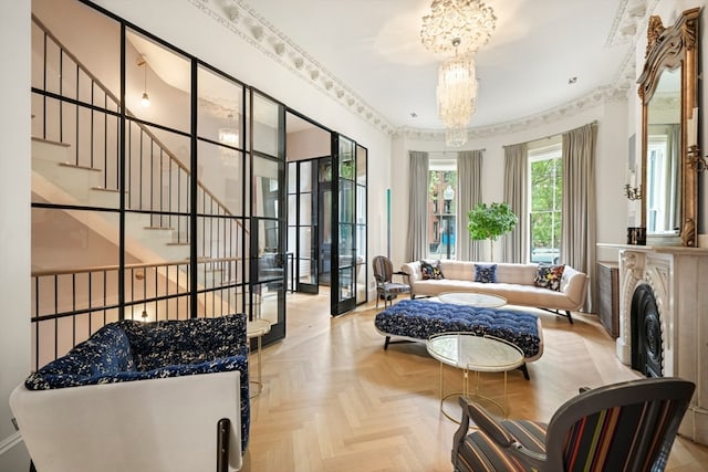 interior space featuring an inviting chandelier, ornamental molding, and light parquet flooring