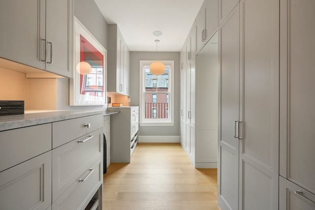 kitchen with light wood-type flooring and hanging light fixtures