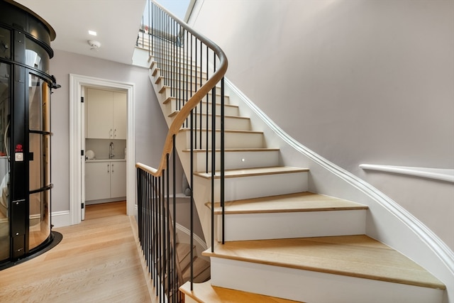 stairs featuring hardwood / wood-style flooring