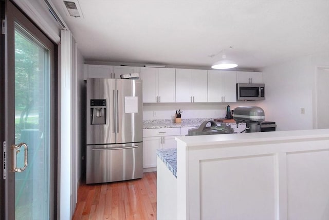 238 Brown Bear Xing Unit 238, Acton, MA 01720 - kitchen with stainless steel appliances, light countertops, light wood-type flooring, and white cabinetry