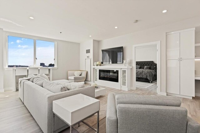 234 Causeway St Apt 709, Boston, MA 02114 - living room with recessed lighting, baseboards, a glass covered fireplace, and light wood-type flooring