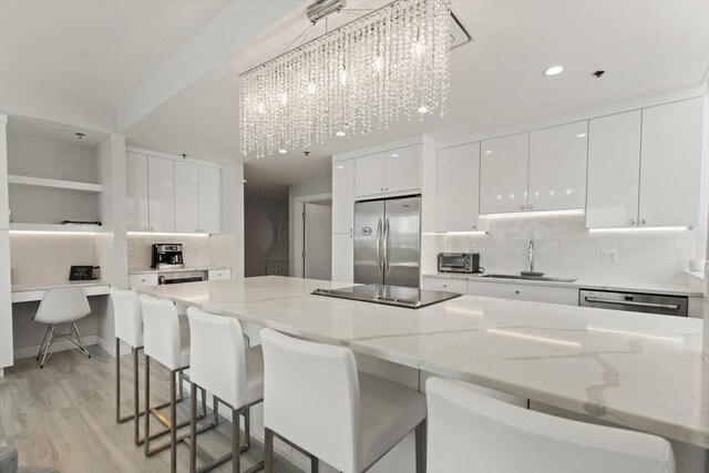 234 Causeway St Apt 709, Boston, MA 02114 - kitchen with a sink, light wood-style floors, stainless steel appliances, white cabinetry, and modern cabinets