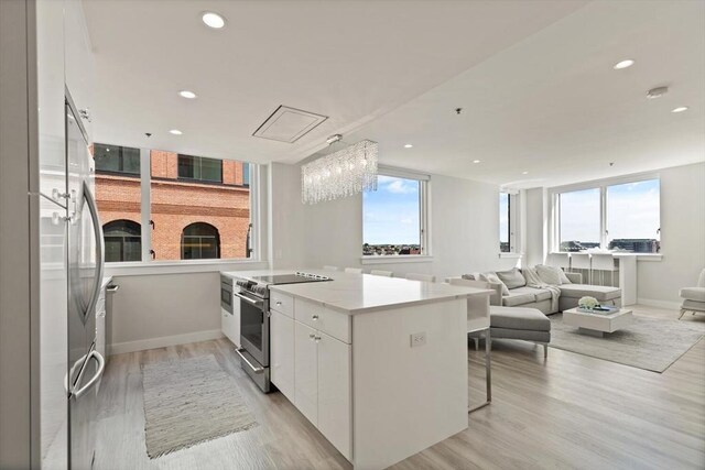 234 Causeway St Apt 709, Boston, MA 02114 - kitchen with plenty of natural light, white cabinetry, baseboards, light wood-type flooring, and stainless steel electric stove