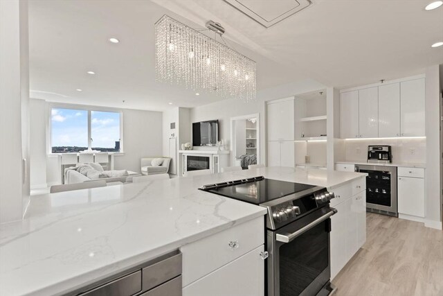 234 Causeway St Apt 709, Boston, MA 02114 - kitchen featuring electric range, wine cooler, open floor plan, modern cabinets, and white cabinetry