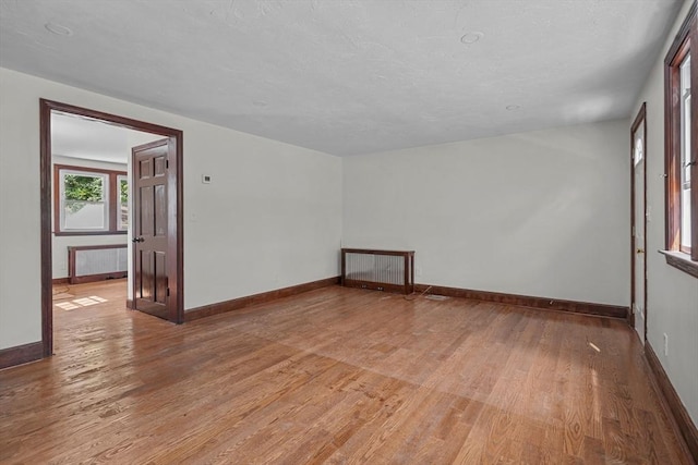 spare room with baseboards and light wood-style floors