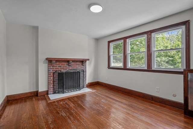 unfurnished living room featuring a fireplace, baseboards, and hardwood / wood-style flooring