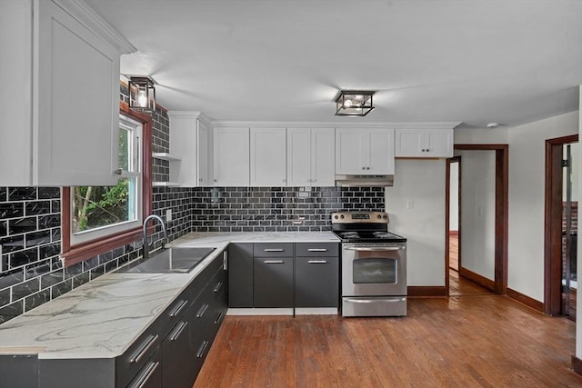 kitchen featuring electric range, under cabinet range hood, a sink, dark wood-style floors, and white cabinetry