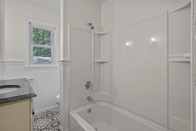 bathroom featuring tile patterned floors, toilet, shower / bathing tub combination, wainscoting, and vanity