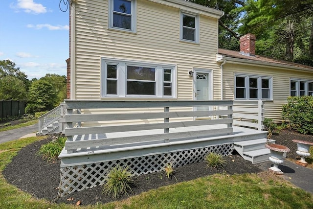 rear view of house with a chimney and a wooden deck