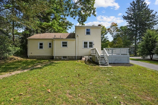 back of property featuring a lawn and a deck