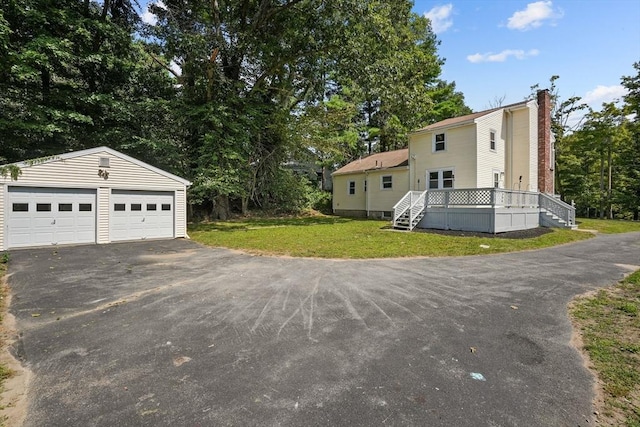 view of property exterior featuring an outbuilding, a yard, and a garage