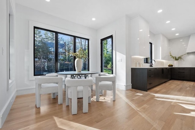 dining area with sink and light wood-type flooring