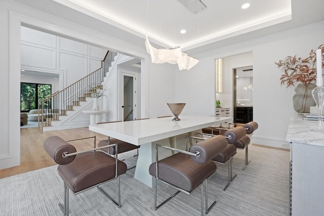 dining area featuring light hardwood / wood-style floors and a tray ceiling