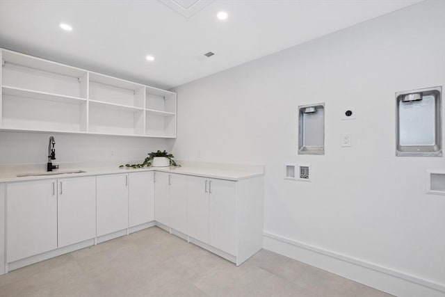 laundry area with hookup for an electric dryer, cabinets, sink, and hookup for a washing machine