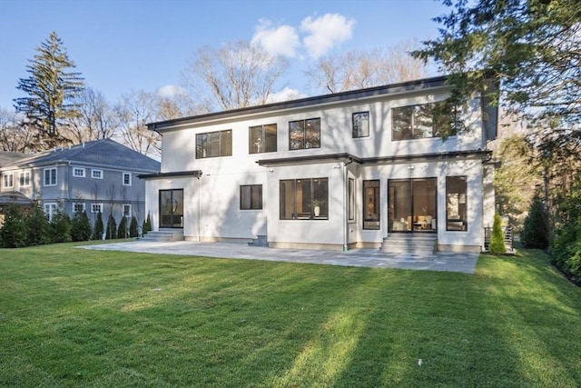 rear view of house with a lawn and a patio