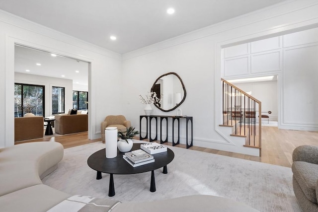 living room with crown molding and light hardwood / wood-style flooring