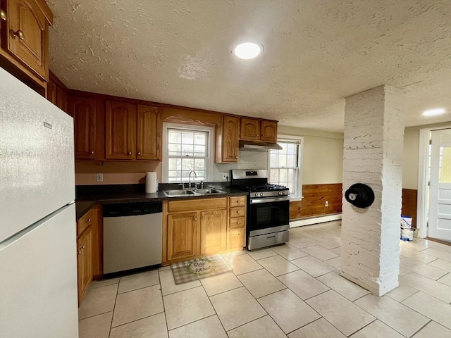 kitchen with appliances with stainless steel finishes, a baseboard radiator, plenty of natural light, and sink