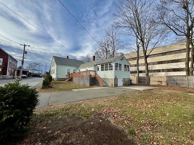 view of property exterior with a lawn and a wooden deck