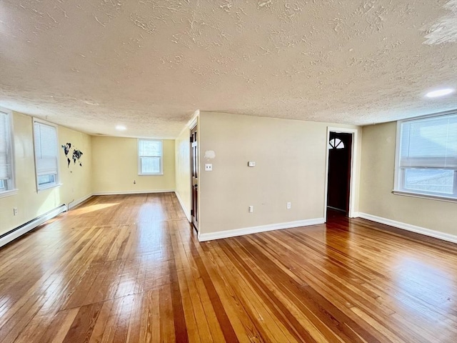 spare room featuring hardwood / wood-style floors and a textured ceiling