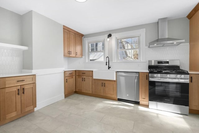 kitchen with appliances with stainless steel finishes, sink, backsplash, and wall chimney exhaust hood