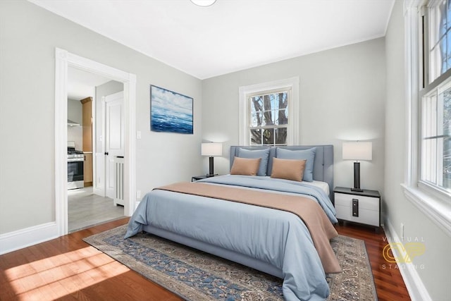 bedroom with multiple windows and dark hardwood / wood-style flooring