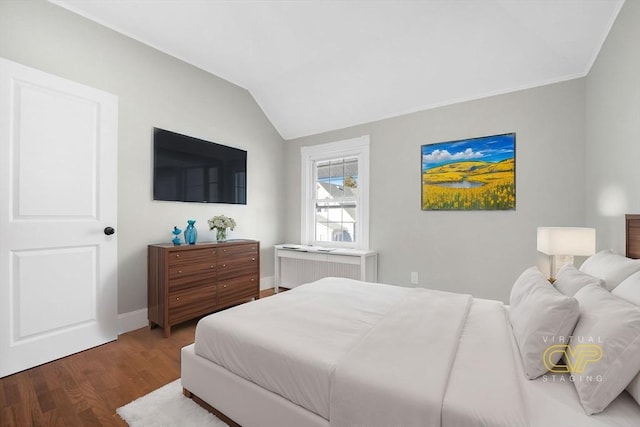 bedroom with lofted ceiling, radiator, and dark hardwood / wood-style floors