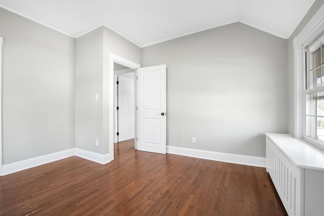 empty room with vaulted ceiling and dark wood-type flooring