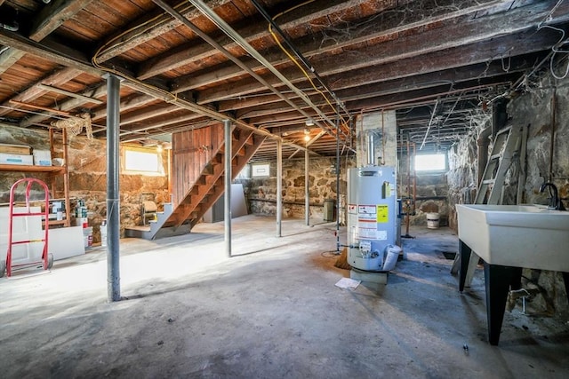 basement with sink, gas water heater, and plenty of natural light