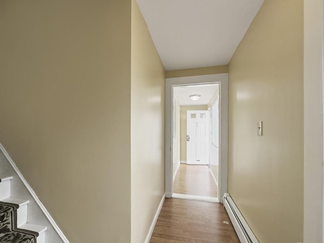 16 Willoughby St, Lawrence, MA 01841 - hallway featuring wood finished floors, a baseboard radiator, baseboards, and stairs