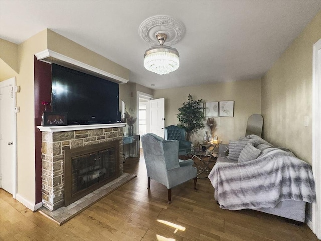 16 Willoughby St, Lawrence, MA 01841 - living area with wood finished floors, a stone fireplace, and a chandelier