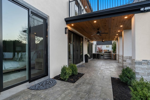 patio terrace at dusk with an outdoor kitchen and ceiling fan