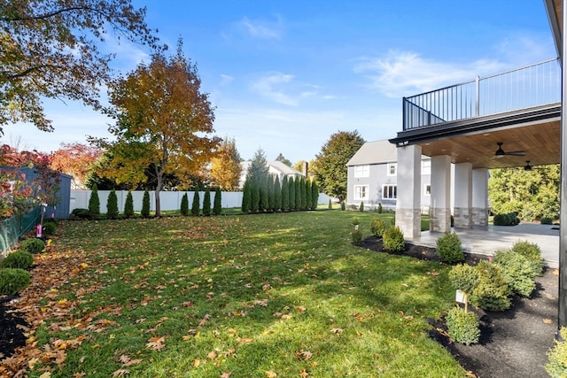 view of yard with a patio, ceiling fan, and a balcony