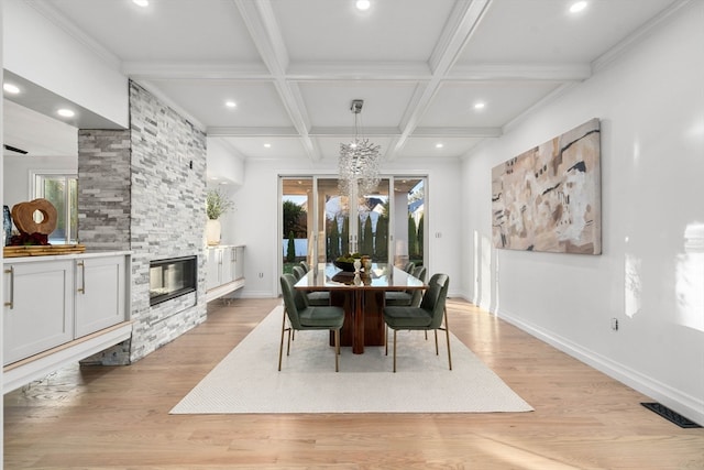 dining space featuring a stone fireplace, a wealth of natural light, and light hardwood / wood-style flooring