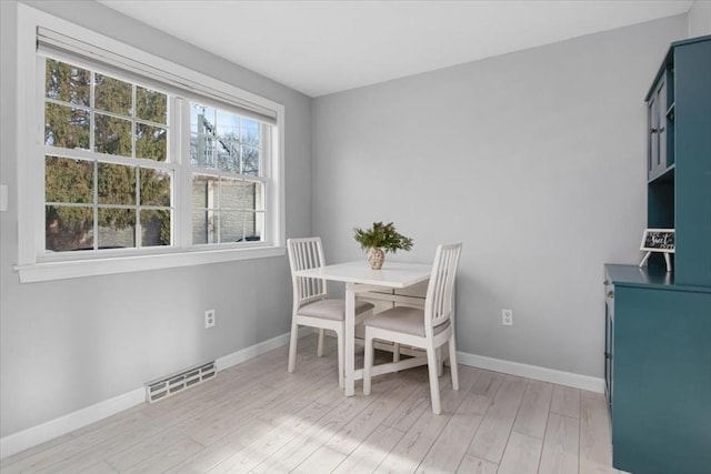 dining area featuring light wood-style floors, baseboards, and visible vents