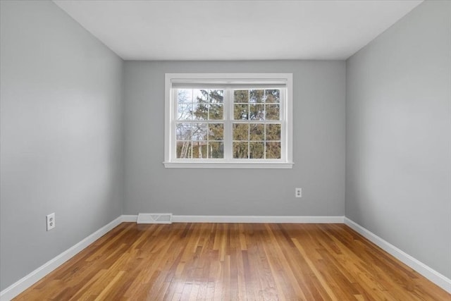 unfurnished room featuring light wood-style floors, baseboards, and visible vents