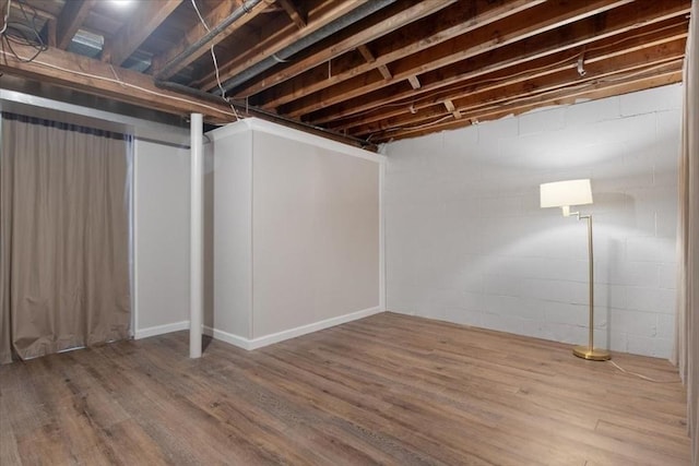 finished basement with concrete block wall and wood finished floors