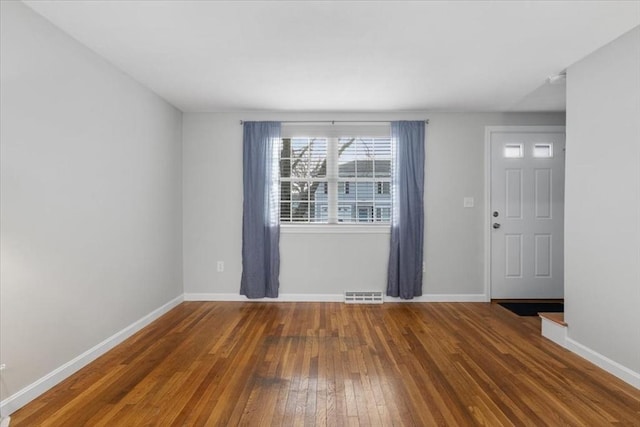 interior space featuring hardwood / wood-style floors, visible vents, and baseboards