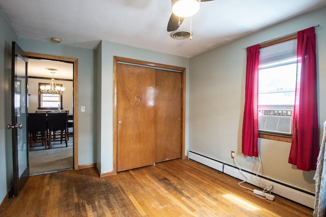 17 Lantern Rd, Revere, MA 02151 - unfurnished bedroom with baseboard heating, wood finished floors, a chandelier, a closet, and baseboards