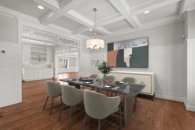 dining area with a notable chandelier, a decorative wall, coffered ceiling, wood finished floors, and beamed ceiling