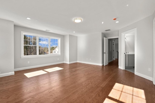 unfurnished room featuring recessed lighting, wood finished floors, visible vents, and baseboards