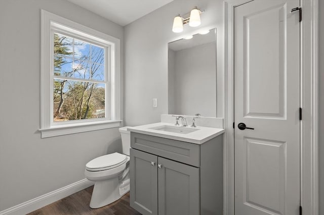 bathroom featuring wood finished floors, vanity, toilet, and baseboards