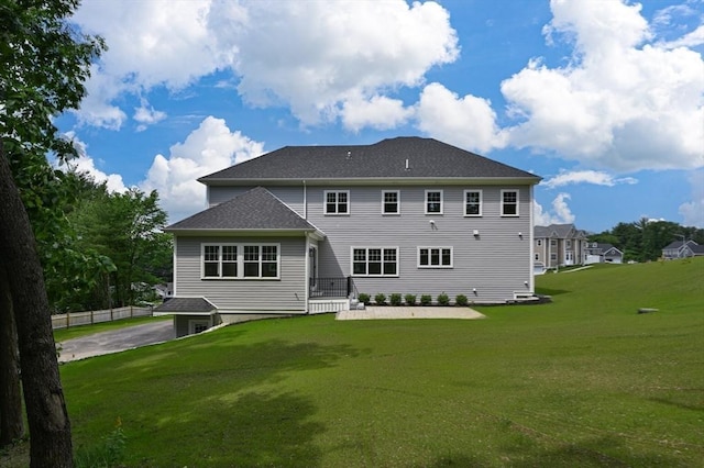 back of house with fence and a yard