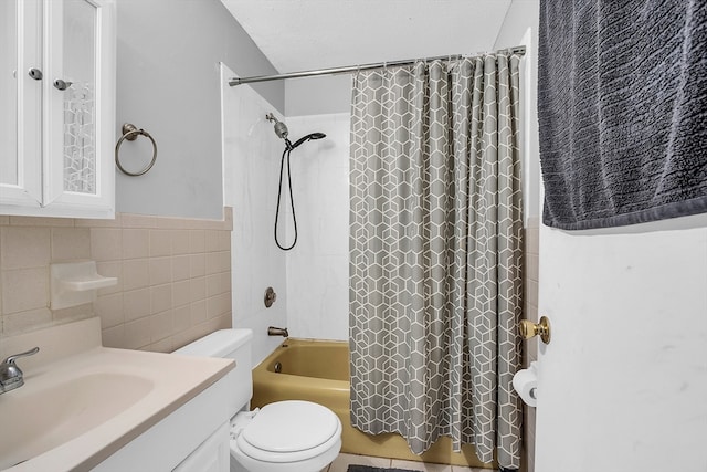 full bathroom with tile walls, vanity, a textured ceiling, toilet, and shower / tub combo with curtain