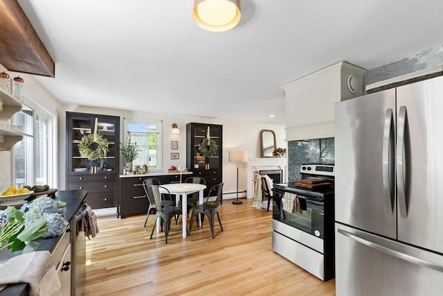6 Manomet Rd, Woburn, MA 01801 - kitchen featuring appliances with stainless steel finishes, light wood-type flooring, a fireplace, and decorative backsplash
