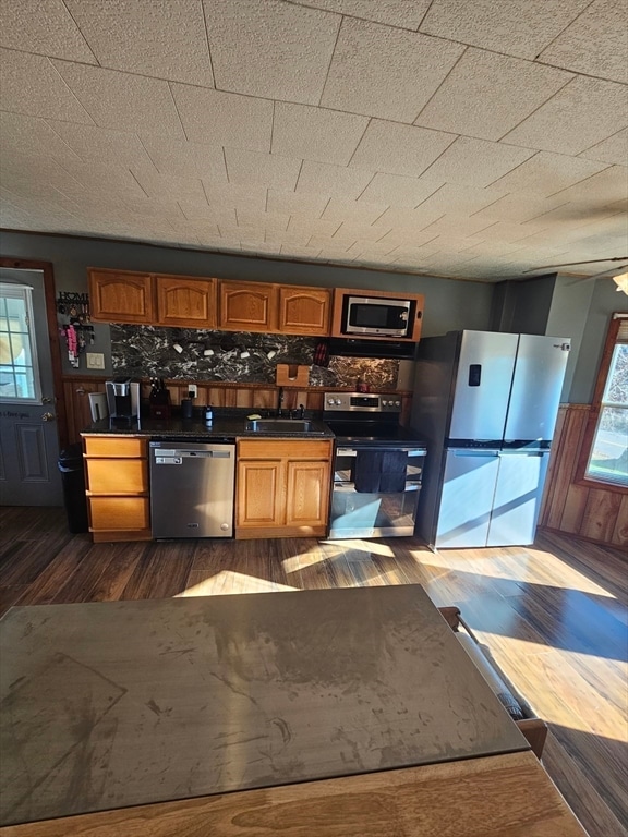 kitchen featuring appliances with stainless steel finishes, tasteful backsplash, ceiling fan, sink, and dark hardwood / wood-style floors