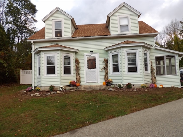 cape cod house with a front yard