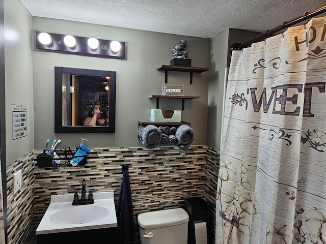 bathroom featuring vanity, toilet, and a textured ceiling